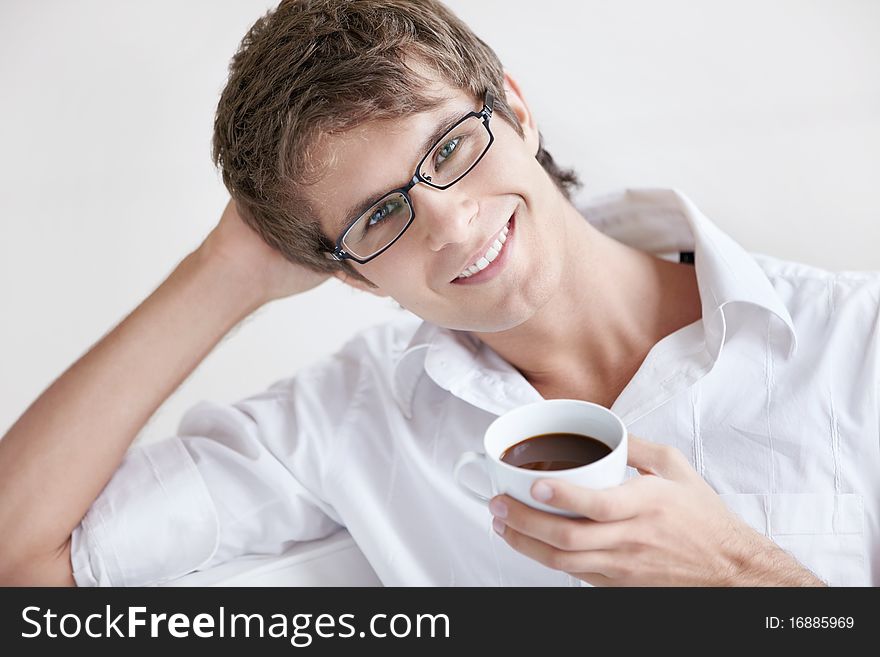 A smiling man holding a cup of coffee. A smiling man holding a cup of coffee
