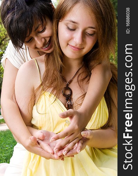 Young girl embracing her friend outdoors. Young girl embracing her friend outdoors