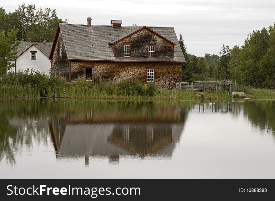 Wooden building reflects in a small lake in Canada