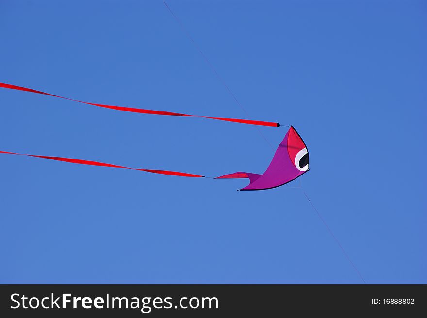 Fish-shaped kite against a vivid blue sky. Fish-shaped kite against a vivid blue sky.
