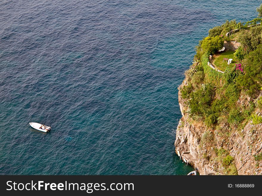 Garden on the sea cliff with a boat floating on the sea