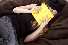 Woman On Bean Bag Looking Behind Book Stock Photos Woman On Bean Bag Looking Behind Book Stock Photos