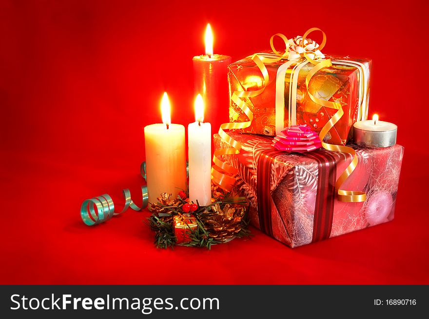 Christmas gifts, ribbons and candles on red background. Christmas gifts, ribbons and candles on red background