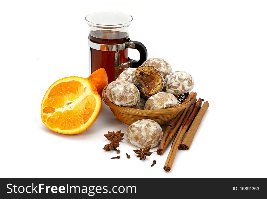 Spicy winter hot drink with orange, spices and spice-cakes on a white background. Spicy winter hot drink with orange, spices and spice-cakes on a white background.
