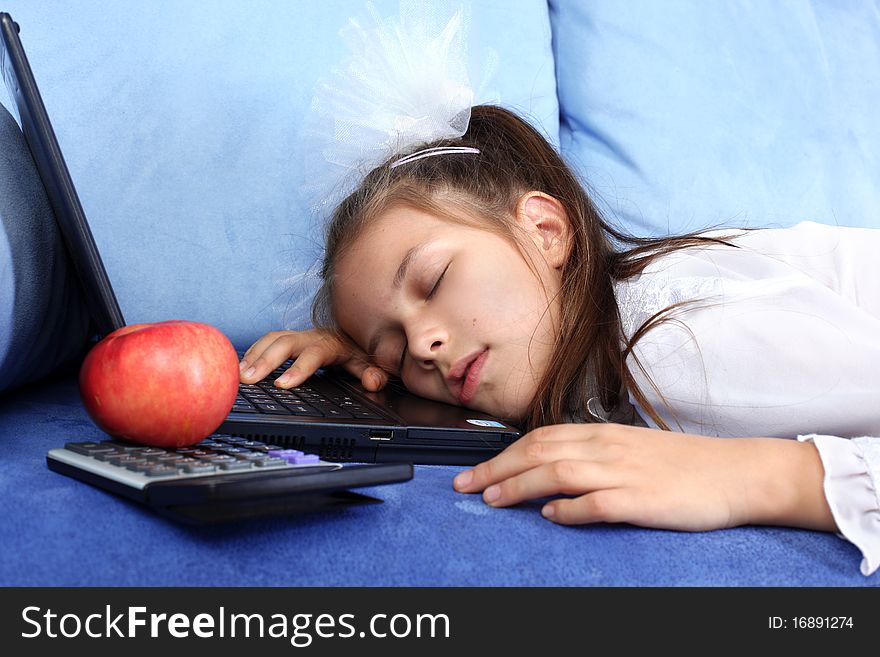 Tired girl sleeping at laptop with red apple