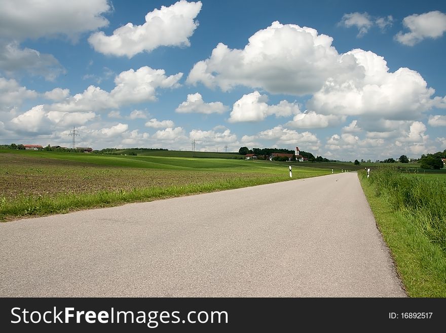 Spring landscape with green grass and blue sky and country road. Spring landscape with green grass and blue sky and country road