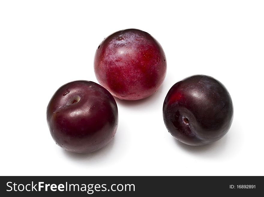 Three red plums isolated on white background