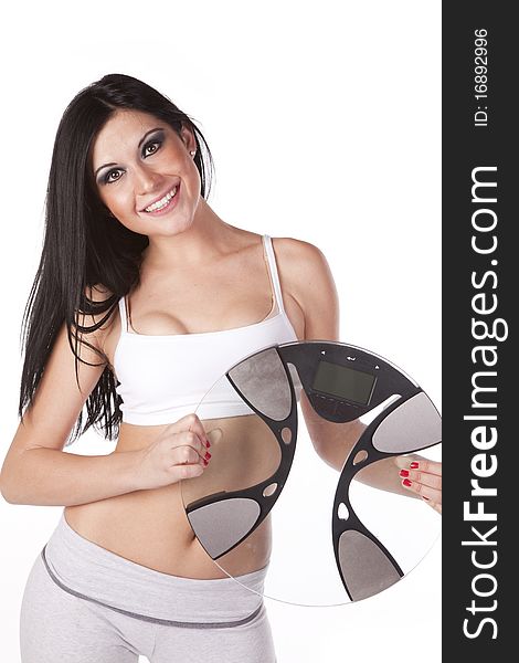 A woman in a white sports bra is holding some scales. A woman in a white sports bra is holding some scales.