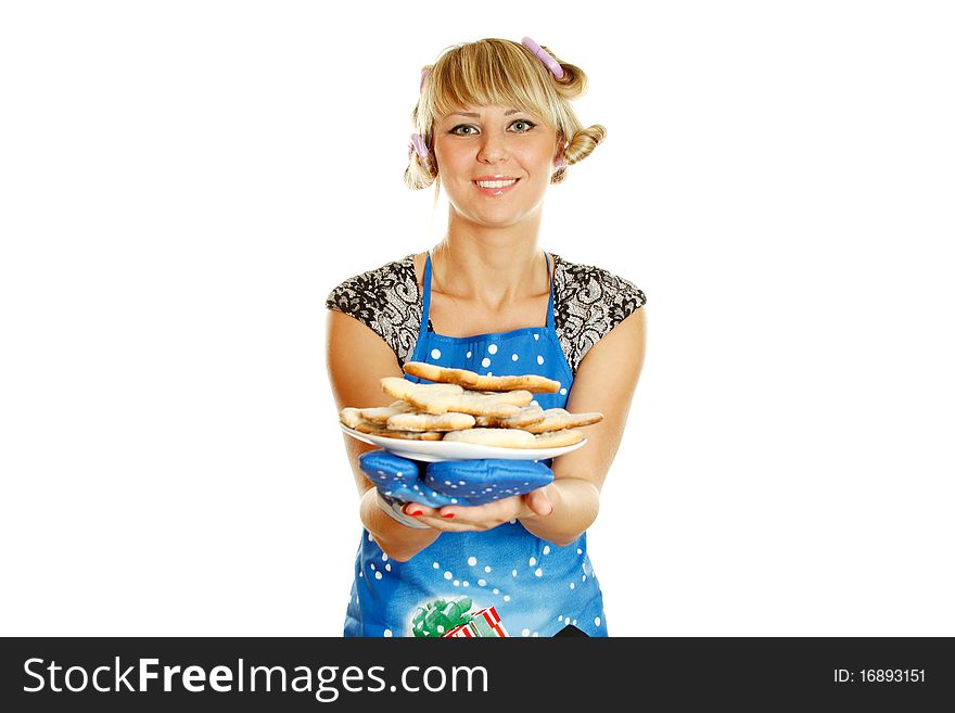 Pretty young woman in an apron and oven gloves holding a plate of gingerbread cookies for the little people christmas. Isolated on a white background. Pretty young woman in an apron and oven gloves holding a plate of gingerbread cookies for the little people christmas. Isolated on a white background