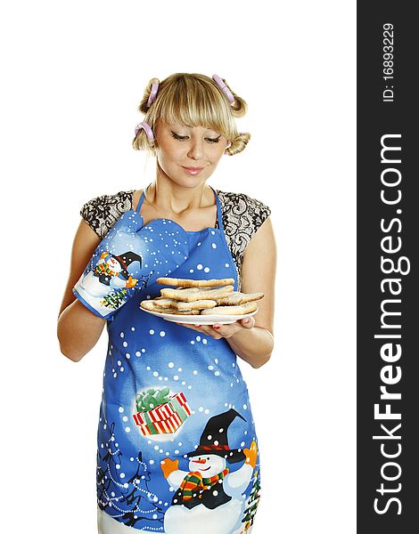 Pretty young woman in an apron and oven gloves holding a plate of gingerbread cookies for the little people christmas. Isolated on a white background. Pretty young woman in an apron and oven gloves holding a plate of gingerbread cookies for the little people christmas. Isolated on a white background