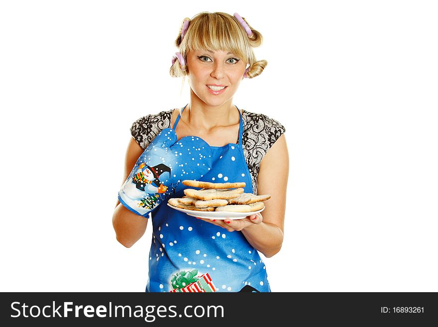 Pretty young woman in an apron and oven gloves holding a plate of gingerbread cookies for the little people christmas. Isolated on a white background. Pretty young woman in an apron and oven gloves holding a plate of gingerbread cookies for the little people christmas. Isolated on a white background