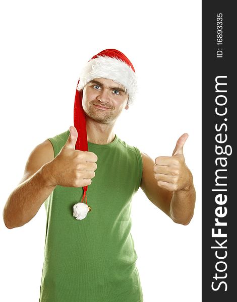 Young man in a Santa Claus hat and green poppy approvingly shows two thumbs raised up. Young man in a Santa Claus hat and green poppy approvingly shows two thumbs raised up