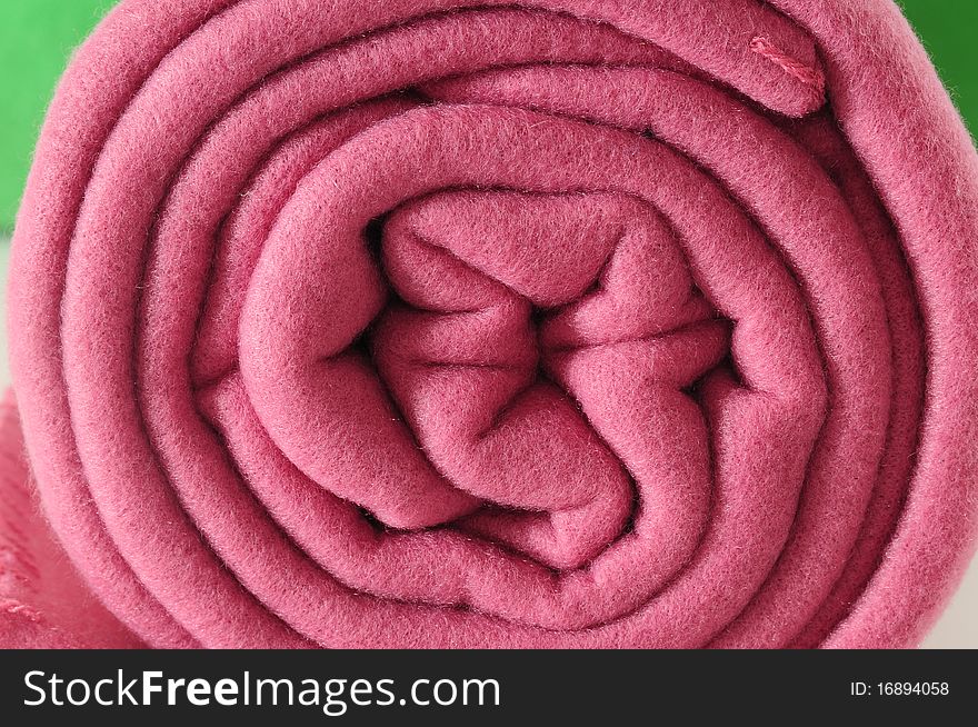 Close up of a rolled up textured blanket. Close up of a rolled up textured blanket.