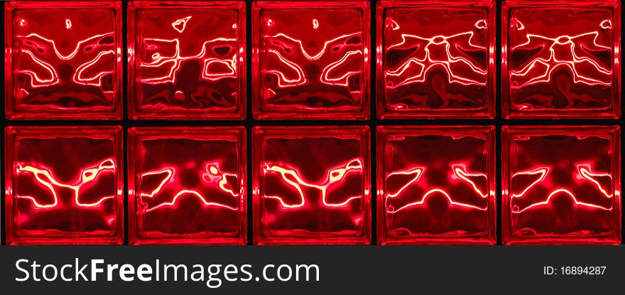 Red neon designs on glass tiles at night. Red neon designs on glass tiles at night