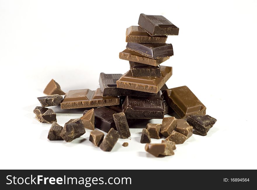 Pieces of dark chocolate stacked in pyramid, isolated on white. Pieces of dark chocolate stacked in pyramid, isolated on white.