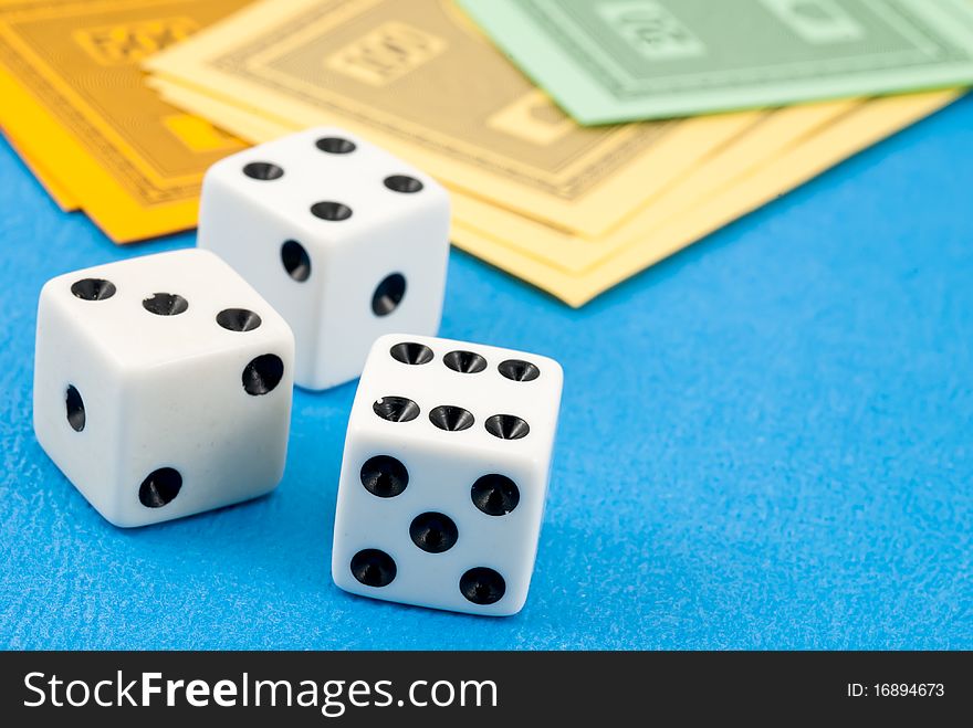 Studio shot of three dice next to the play money. Studio shot of three dice next to the play money.