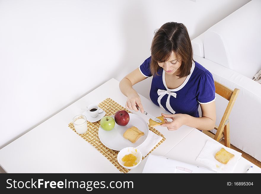 Young woman in breakfast, eating and using laptop. Young woman in breakfast, eating and using laptop