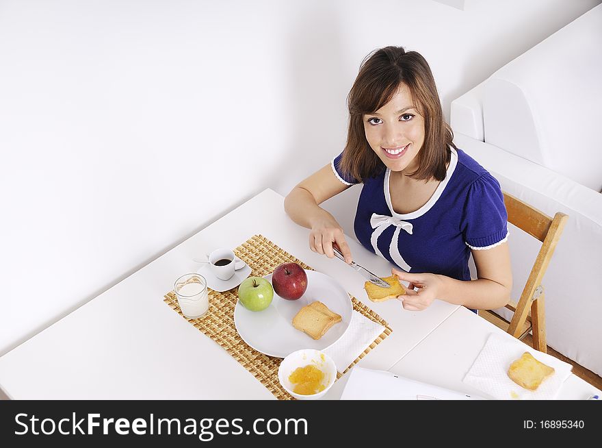 Young woman in breakfast, eating and using laptop. Young woman in breakfast, eating and using laptop