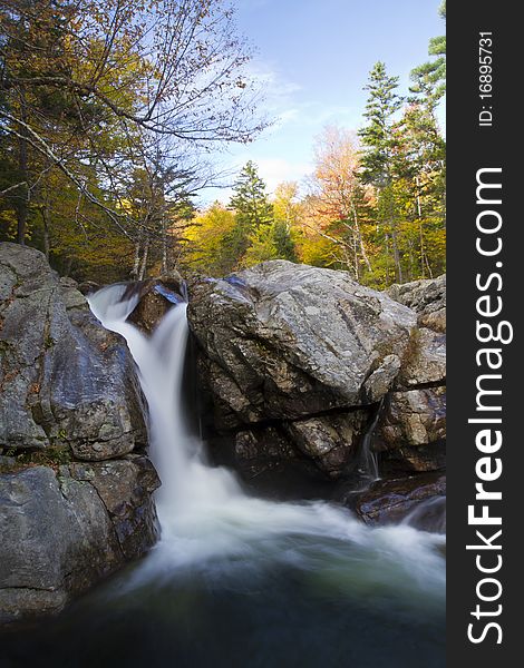 The Ellis river squeezes through a chute in the rocks making a beautiful waterfall in the fall foliage of Pinkham Notch, New Hampshire. The Ellis river squeezes through a chute in the rocks making a beautiful waterfall in the fall foliage of Pinkham Notch, New Hampshire.