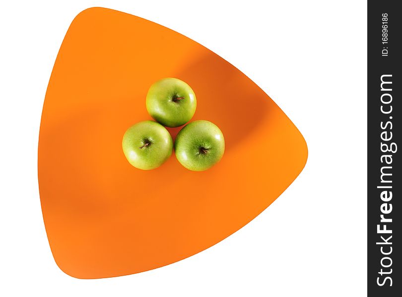 Green apples on an orange tray over white background. Green apples on an orange tray over white background.
