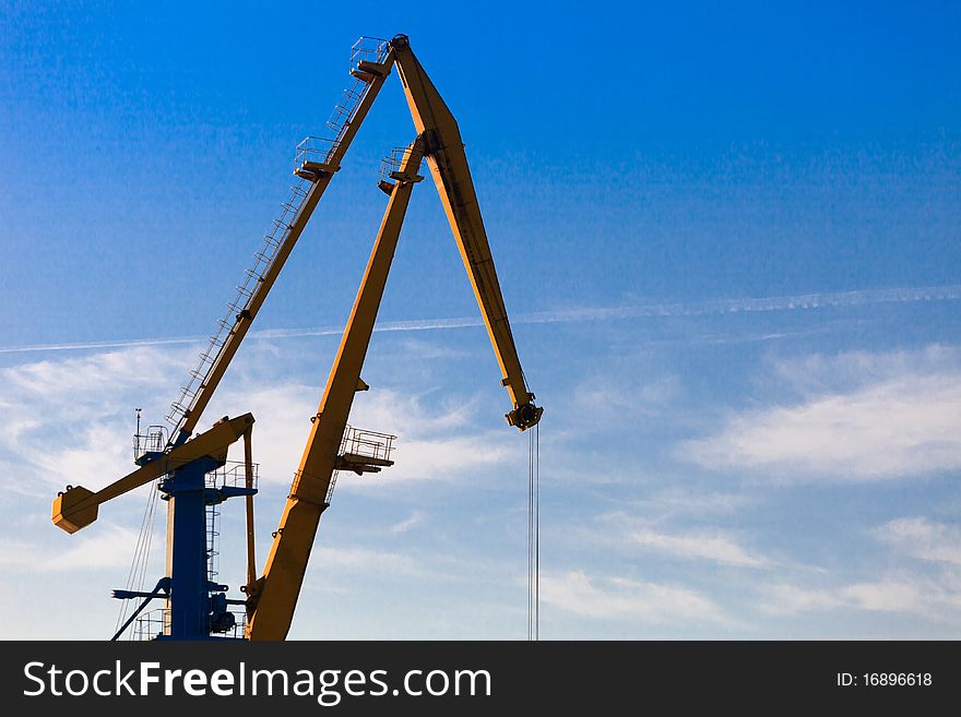 Yellow nautical crane on the blue sky. Yellow nautical crane on the blue sky