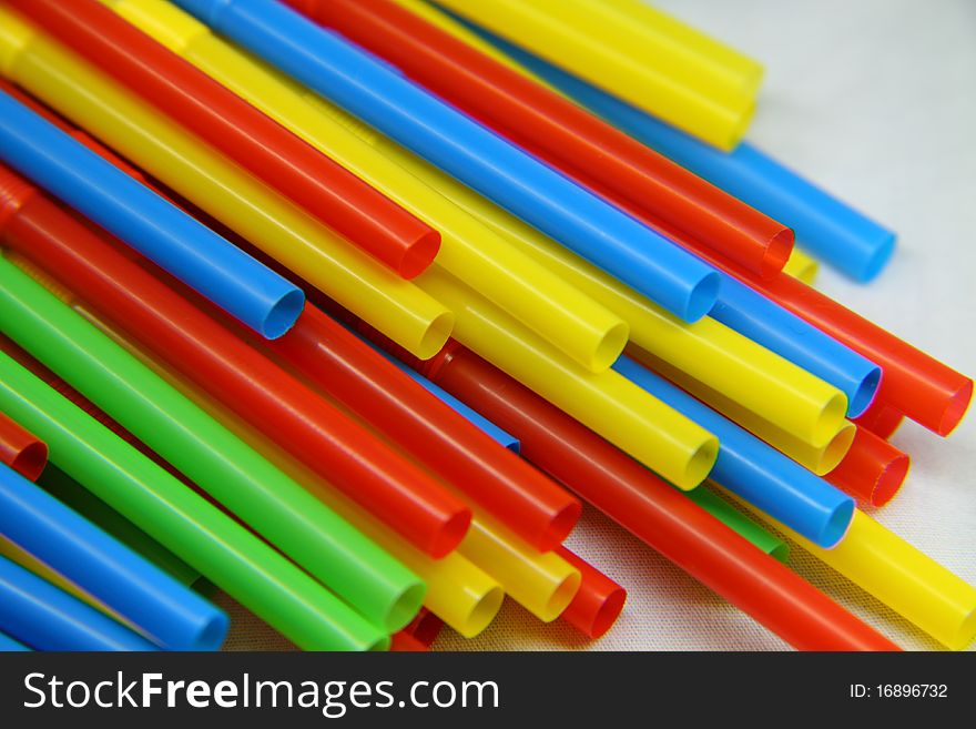 Colored tubes for a cocktail on a white background. Colored tubes for a cocktail on a white background