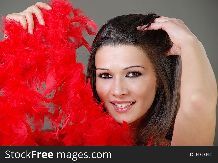 Beautiful portrait of a girl smiling and holding red feathers. Beautiful portrait of a girl smiling and holding red feathers