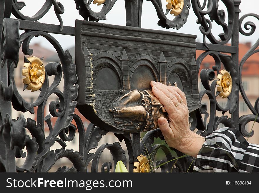 Touching a copper relief for good luck