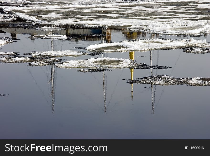 Ice drift on Neva with reflections of the ship and historical buildings