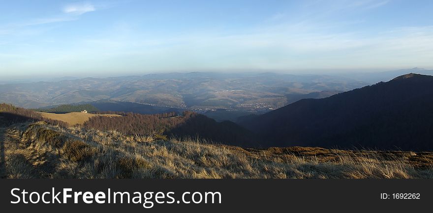 Mountain panorama with small town on background. Mountain panorama with small town on background