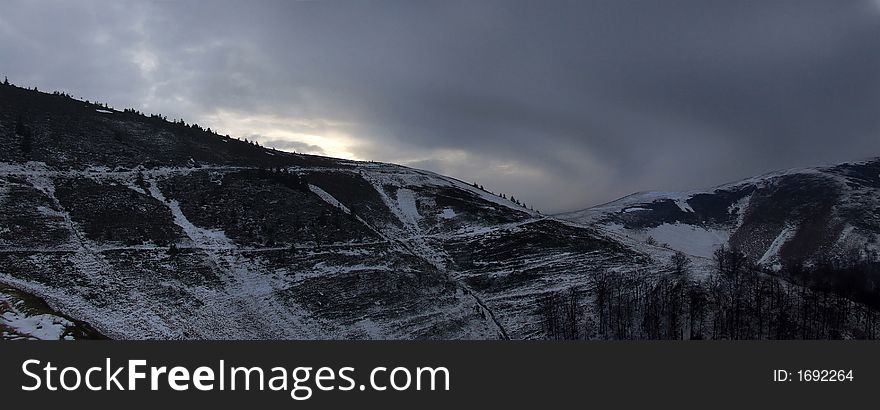 Dark evening with sunrays touching the edge of the mountain