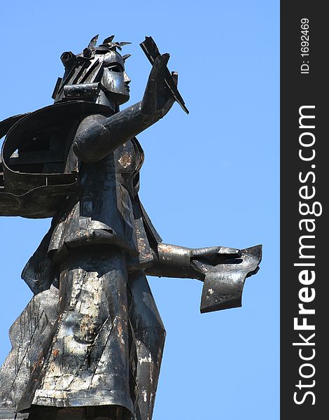 Sculpture with a feather and the book on a blue background