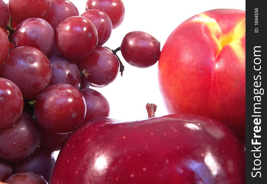 A bunch of fruit, including, apple, apricot and grapes