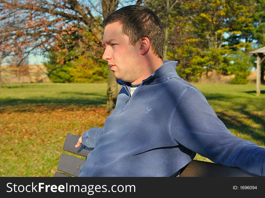 Young man sitting on bench. Young man sitting on bench