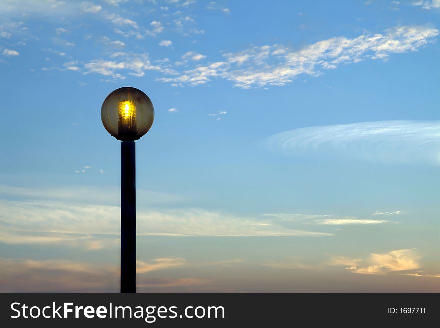 Lighted public lamp against the sky at sunset. Lighted public lamp against the sky at sunset