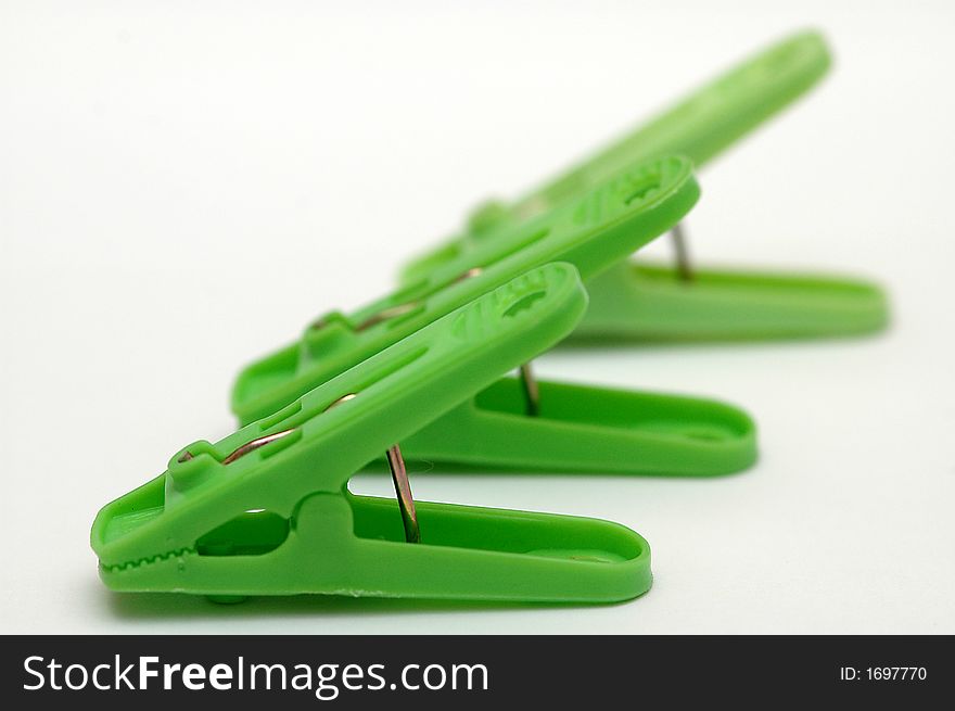 3 green clothespins on a white background.