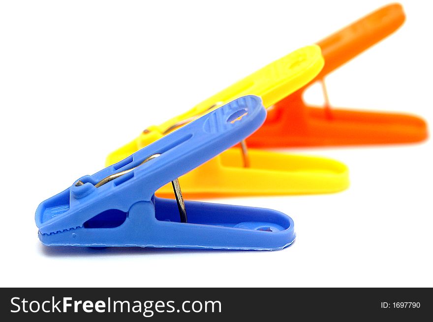 3 colorful clothespins with white background. Blue, yellow and orange.