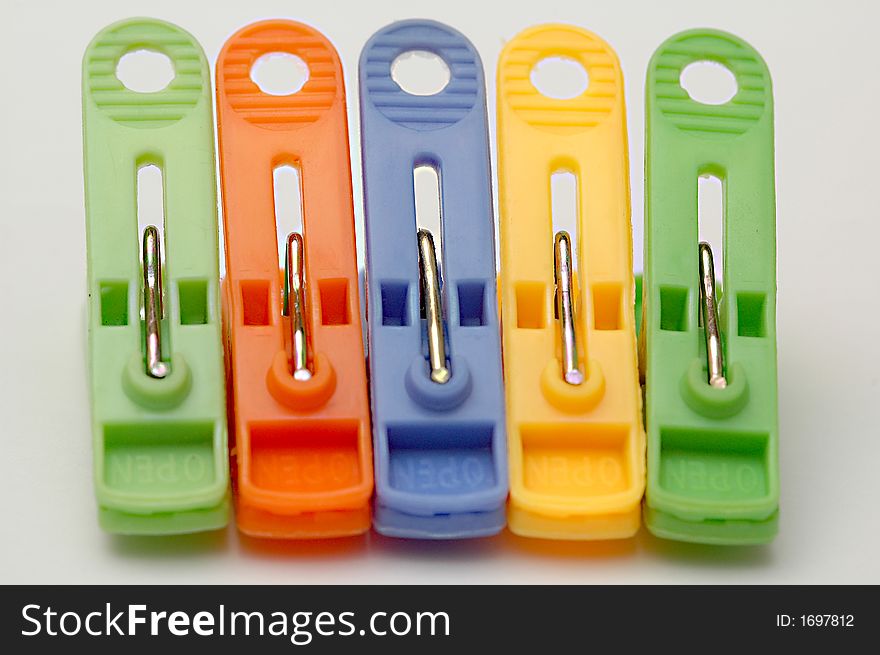 Colourful clothespins in a row with white background. Colourful clothespins in a row with white background.