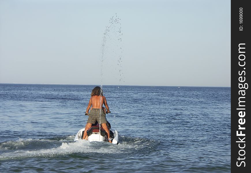 Young guy riding a jet ski. Young guy riding a jet ski