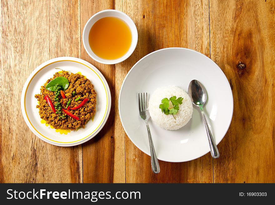 Spicy pork basil with rice and soup on wood background, thai food. Spicy pork basil with rice and soup on wood background, thai food.