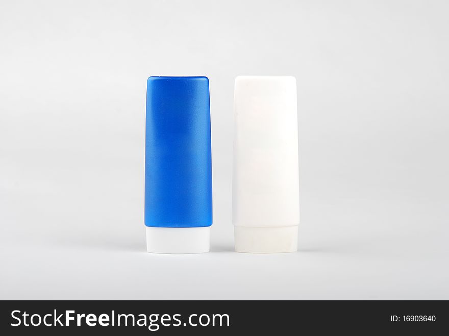 Two cosmetic bottles isolated on white background .