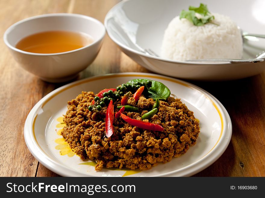 Spicy pork basil with rice and soup on wood background,thai food. Spicy pork basil with rice and soup on wood background,thai food.