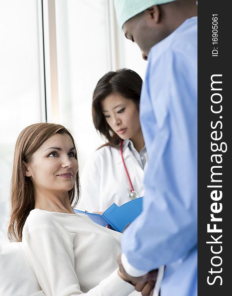 Doctor and surgeon speaking with a female patient. Doctor and surgeon speaking with a female patient