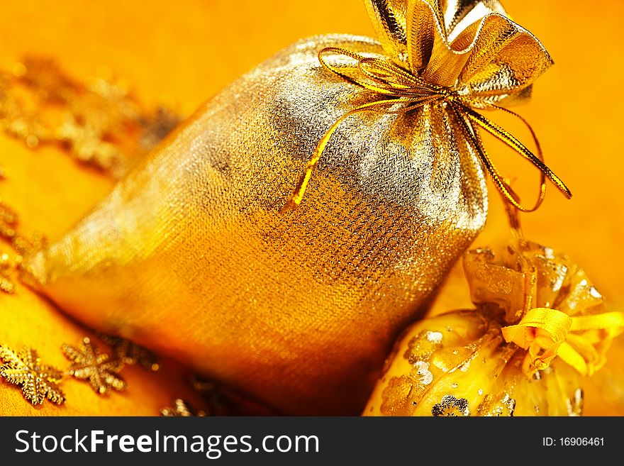 Two golden christmas gift sacks with ribbons over yellow background. Two golden christmas gift sacks with ribbons over yellow background