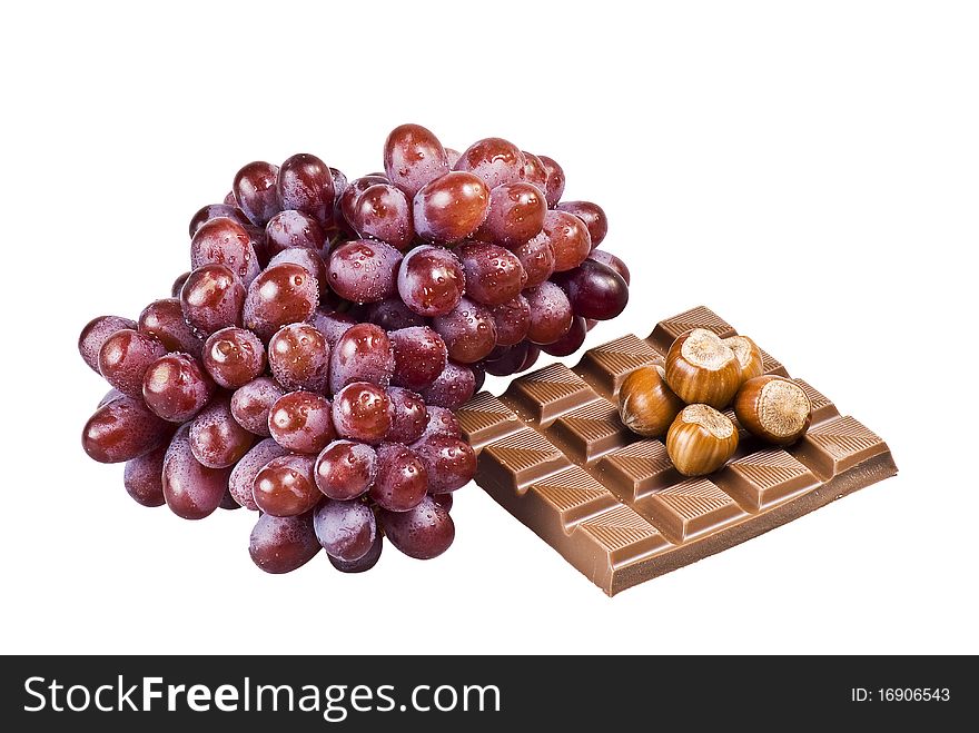 Red grapes with chocolate and nuts in shells on white background. Red grapes with chocolate and nuts in shells on white background