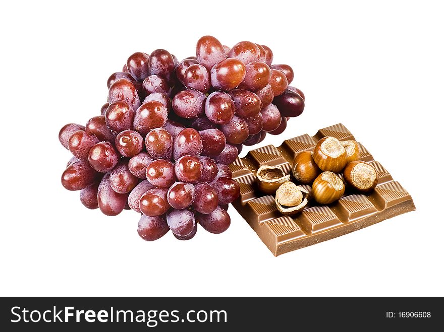 Red grapes with chocolate and nuts in shells on white background. Red grapes with chocolate and nuts in shells on white background