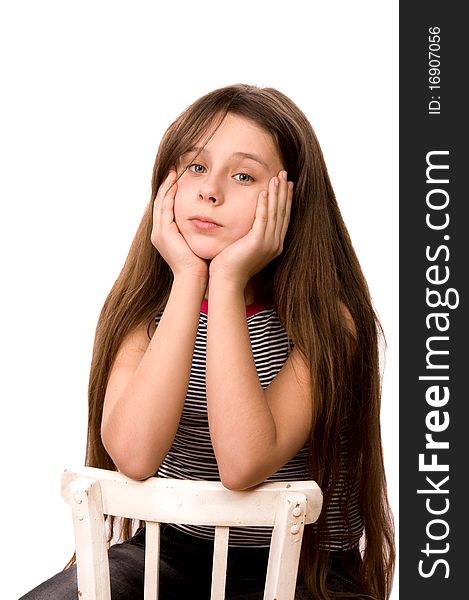 Pretty girl in the age of eleven looking ahead sitting on a chair isolated on white at age. Pretty girl in the age of eleven looking ahead sitting on a chair isolated on white at age