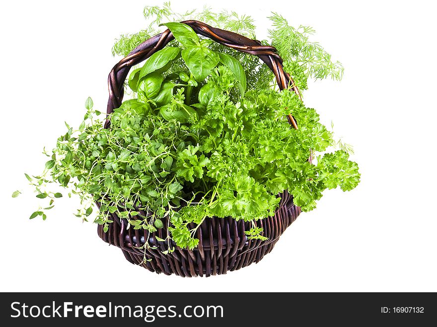 Basket of basil, thyme, dill, and parsley over white background. Basket of basil, thyme, dill, and parsley over white background