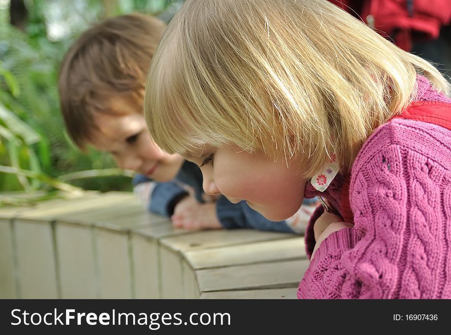 Blond girl and boy looking down of fencing. Blond girl and boy looking down of fencing