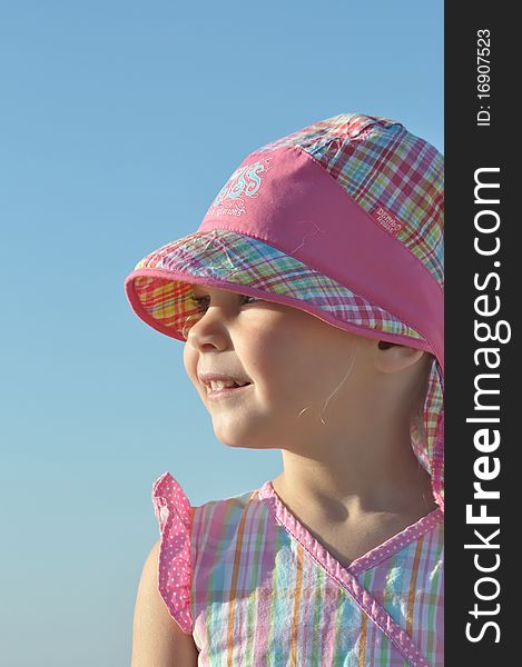 Smiling little girl in pink hat looking afar. Smiling little girl in pink hat looking afar